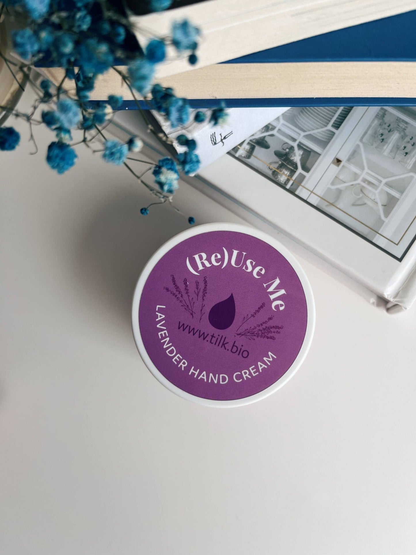 2. Top view of Tilk! ReUse Me Lavender Hand Cream on a desk with flowers