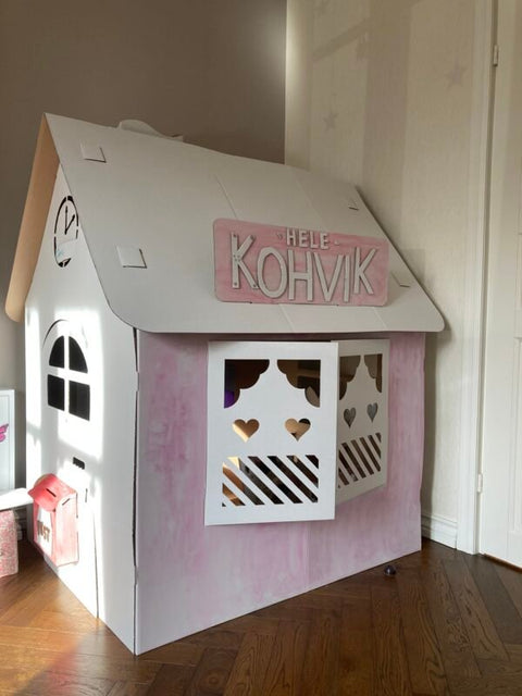 5. SEIK cardboard house for kids with pink cafe sign and heart-shaped cutouts, shown indoors