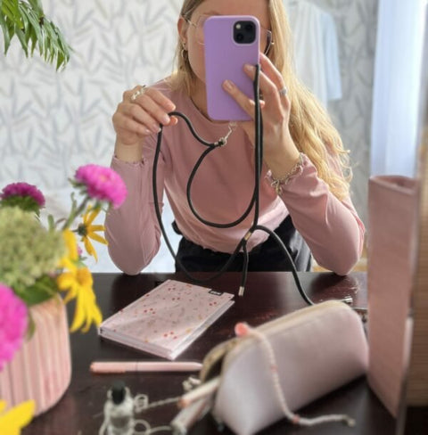 2. Woman demonstrating SEIK Universal Phone Strap in Midnight, highlighting adjustable length