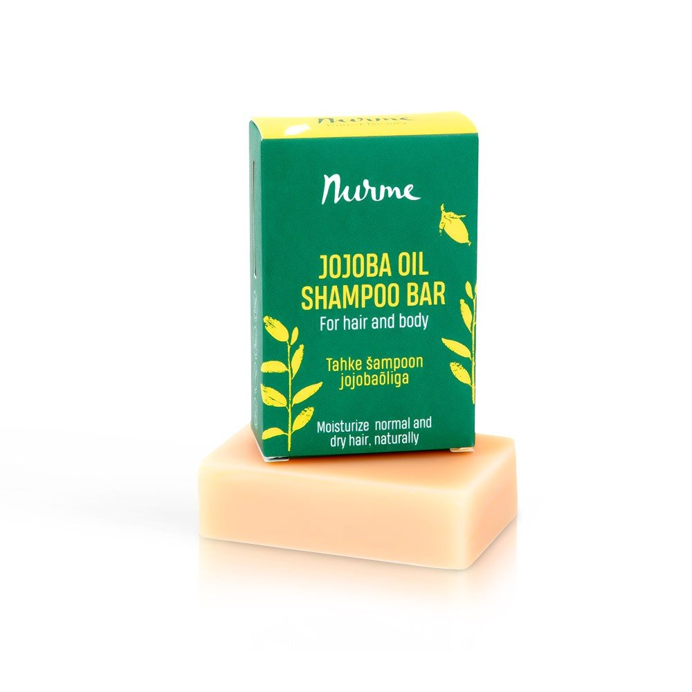 2. Nurme Jojoba Oil Shampoo Bar in green packaging with yellow text, placed on top of a beige soap bar against a white background
