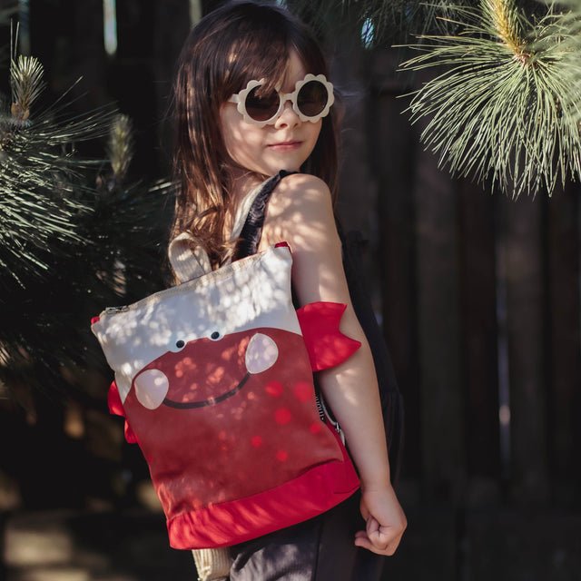 1. Girl wearing Muni kids crab backpack outdoors, showcasing playful design and adjustable straps