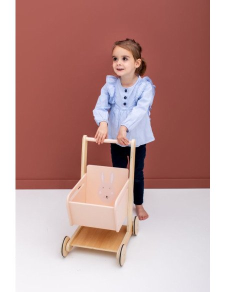 1. Child pushing Trixie Baby Wooden Shopping Cart with Mrs. Rabbit design on pink background