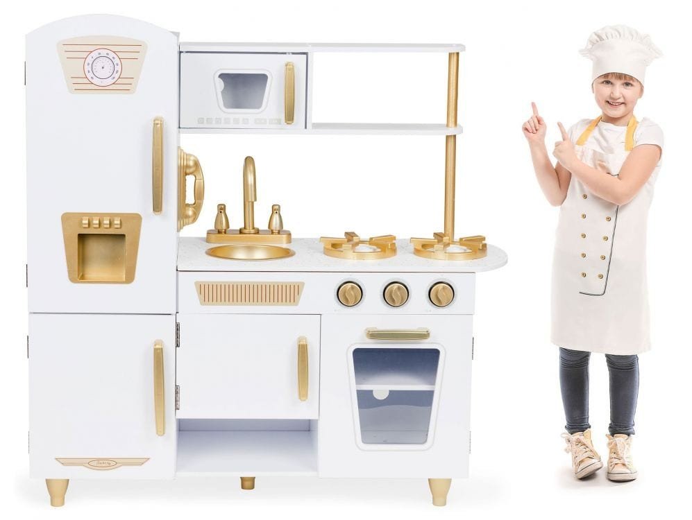 9. Child dressed as chef next to Angelove white and gold play kitchen