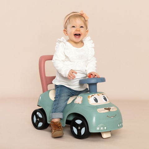 1. Happy toddler riding Smoby Little Ride-on Pusher in pastel colors, indoor setting