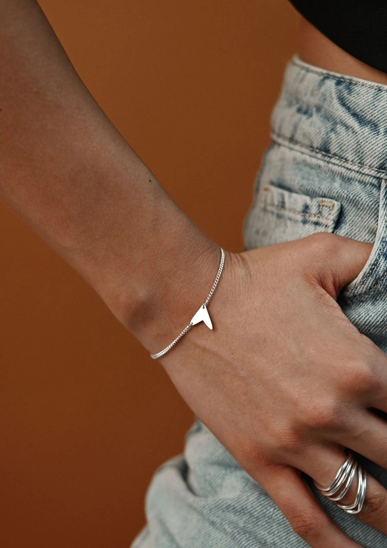 5. Women's Love Bracelet in silver worn with black outfit, highlighting elegant and versatile style