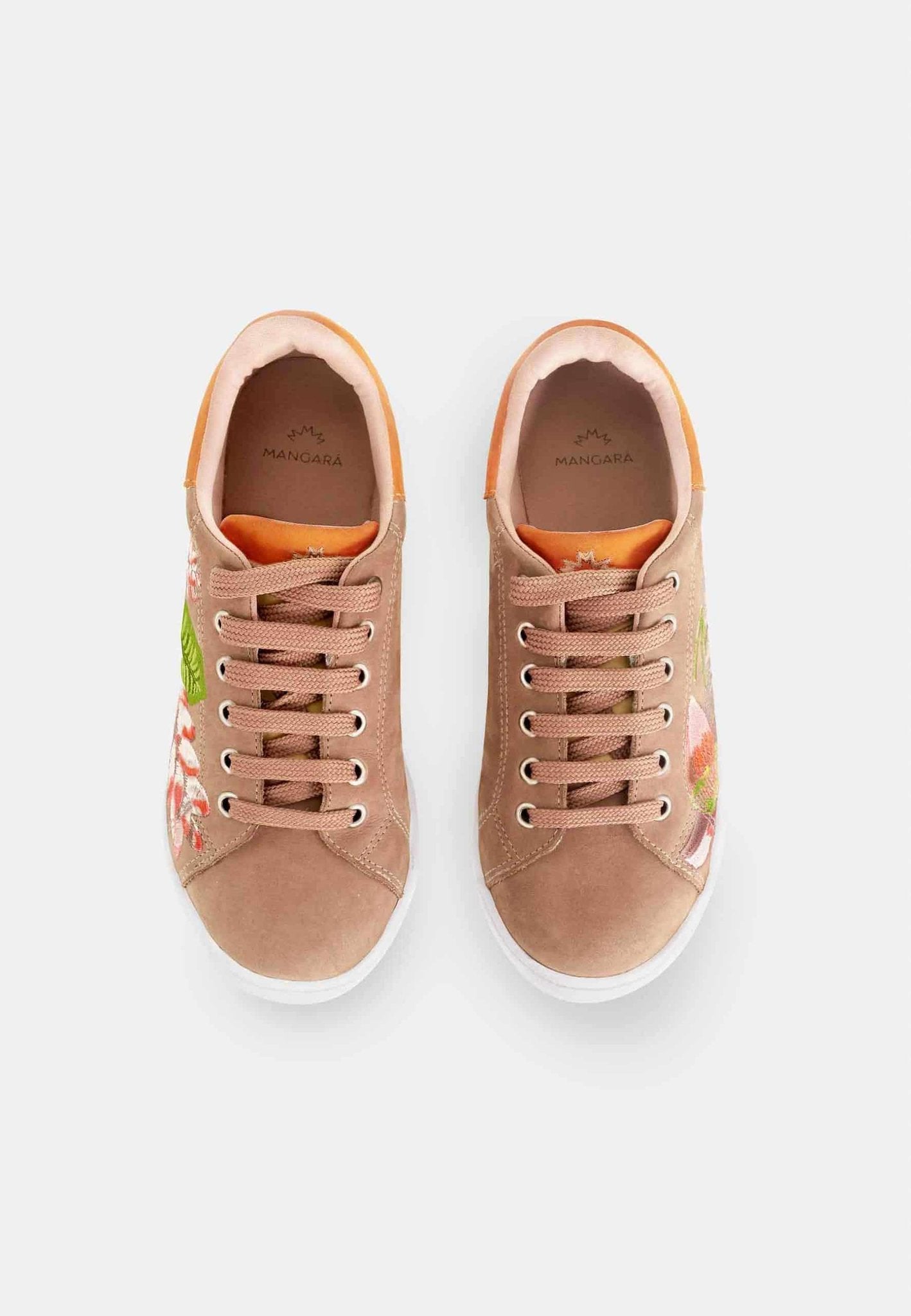 5. Women's Mangará embroidery suede sneakers in brown, worn with a black dress, shown on a boardwalk by the beach