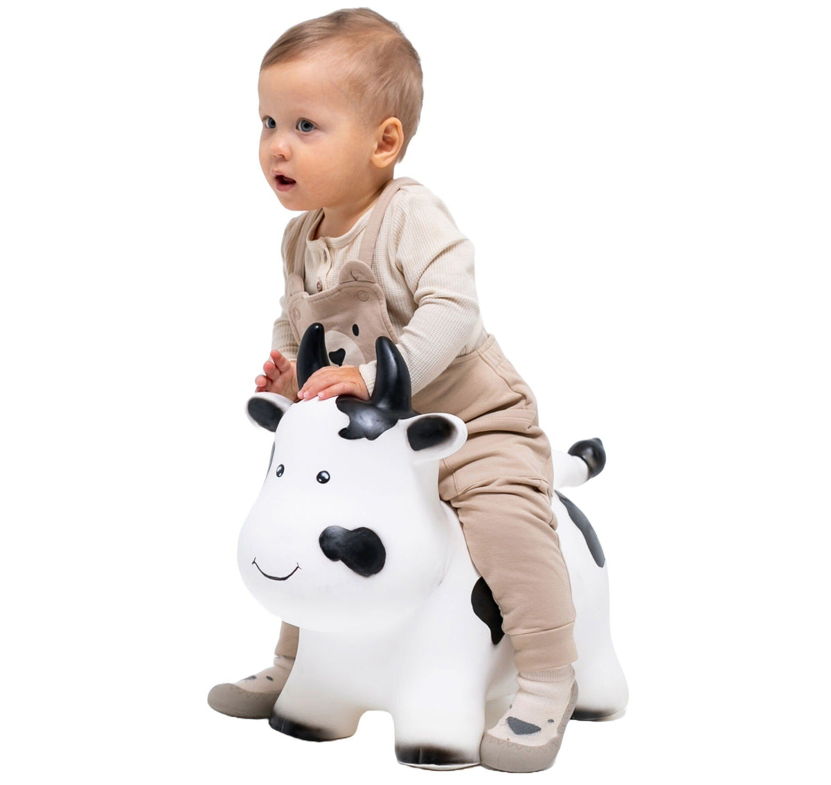 4. Toddler in beige outfit riding Gerardo's Toys My First JUMPY white cow hopper toy