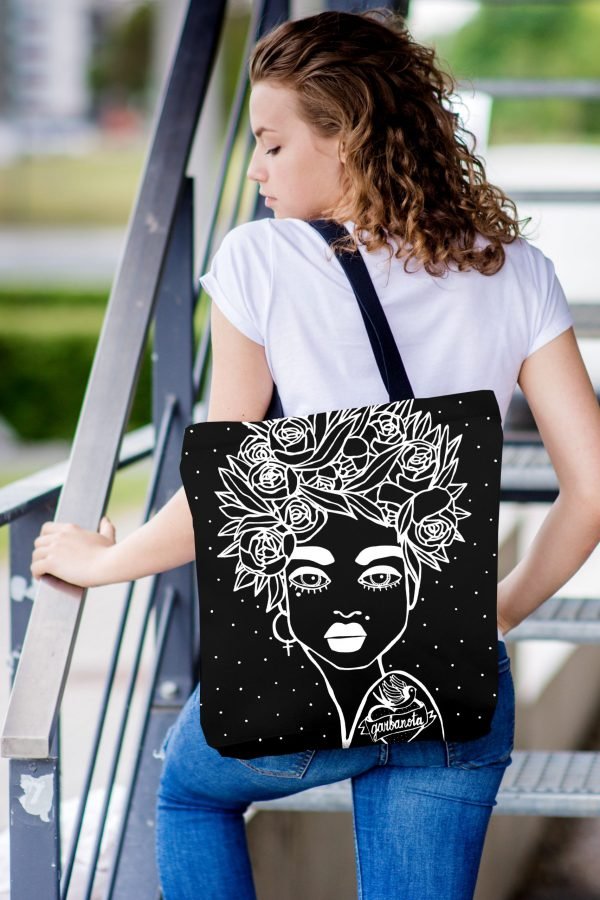 1. Woman wearing Garbanota Naomi handbag with floral haircut design in black, styled casually on stairs
