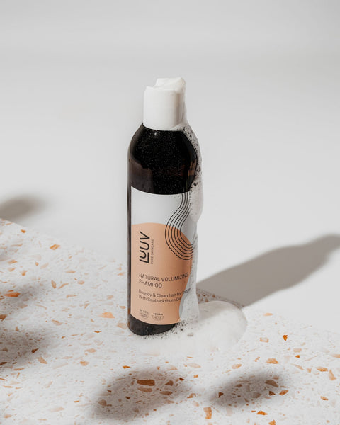 2. LUUV Natural Volumizing Shampoo with sea buckthorn oil, shown with lather on a terrazzo surface