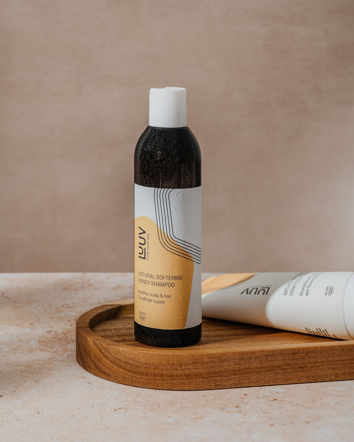 2. LUUV Natural Softening Honey Shampoo bottle on wooden tray, highlighting sleek design and eco-friendly label