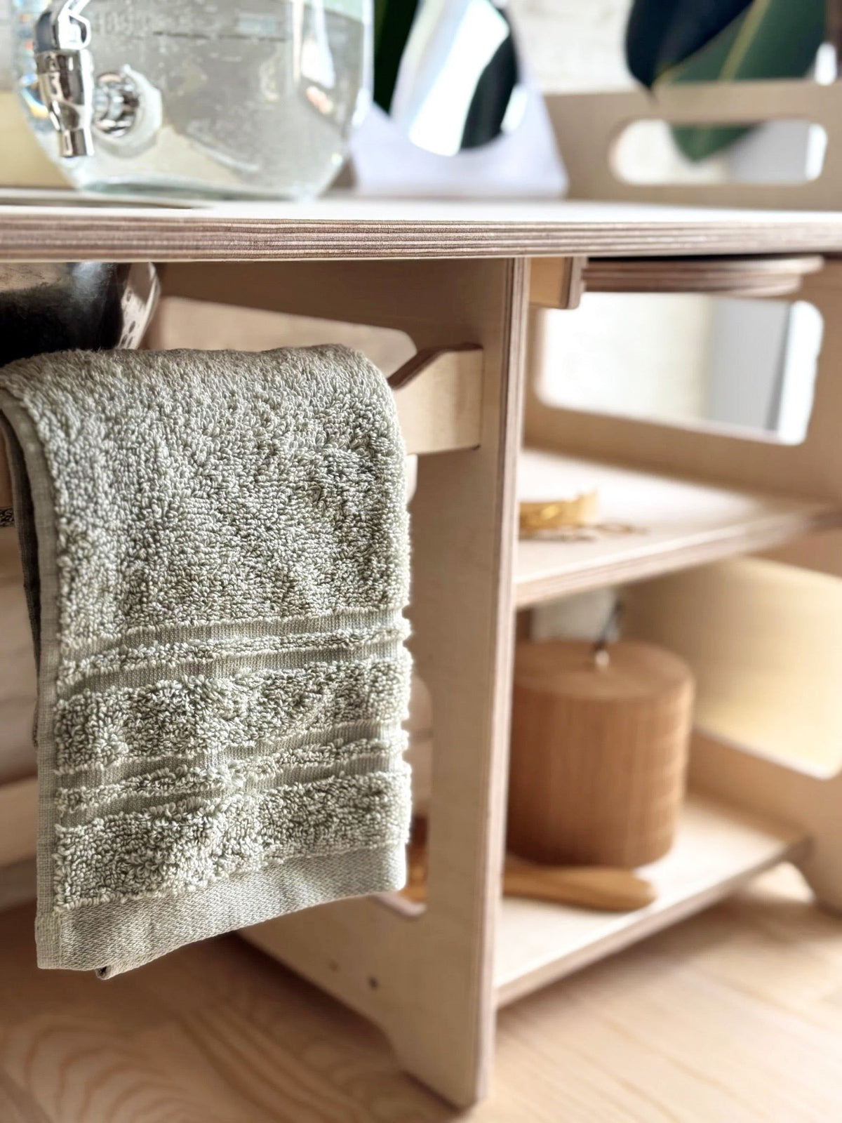 2. Close-up of Montessori washbasin showing towel rack and open shelf with wooden accessories