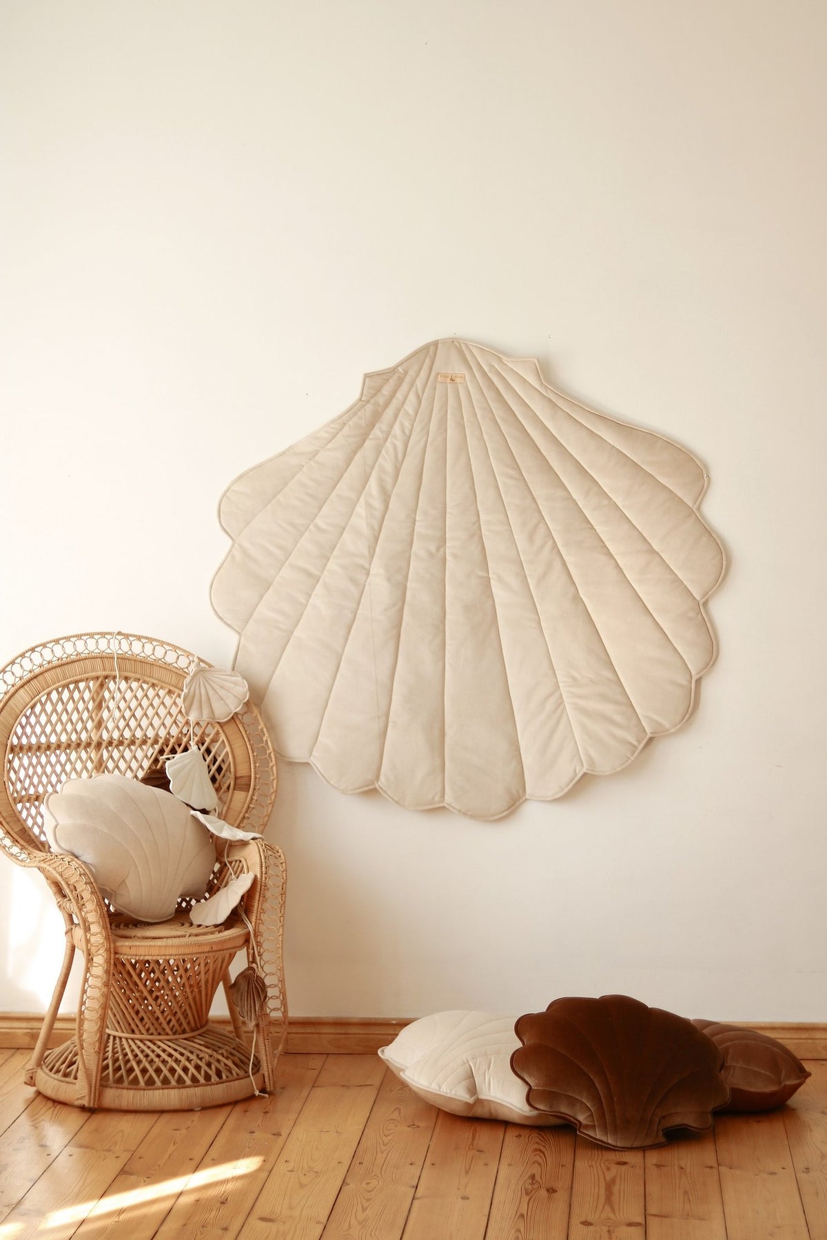 4. Beige ginkgo leaf-shaped playmat on wall with wicker chair and cushions