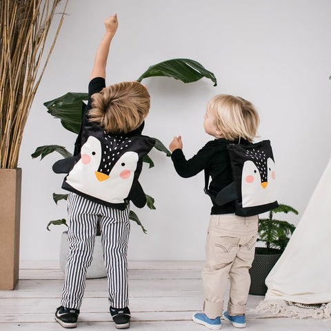 2. Kids with Muni Penguin backpacks reaching up in a bright room