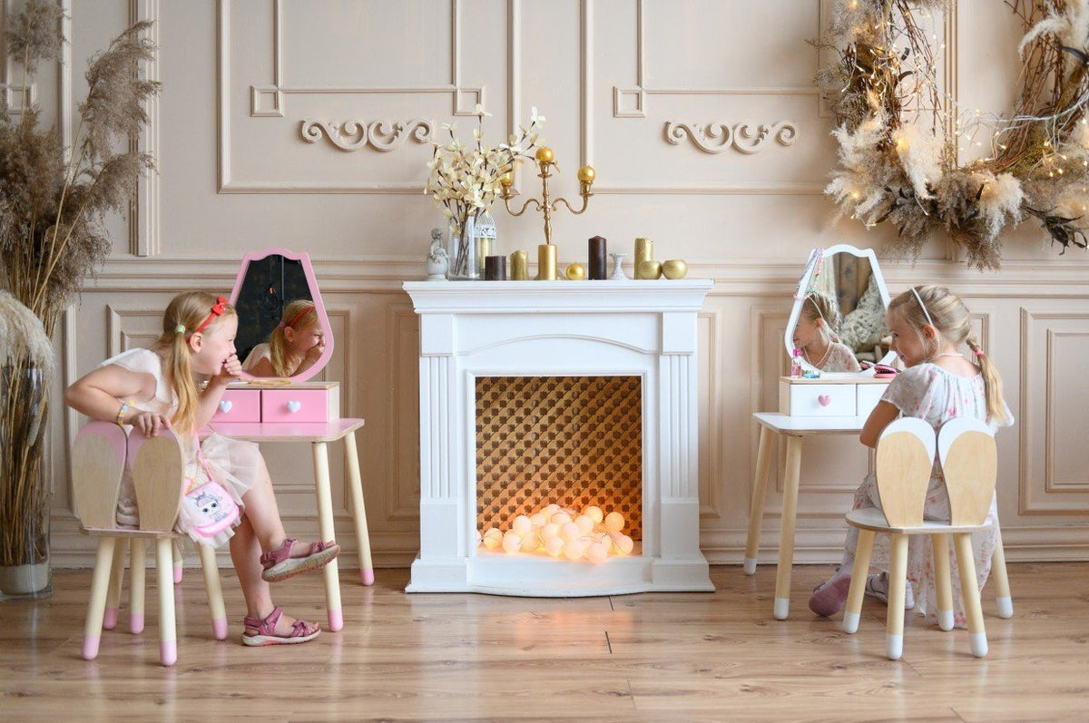 1. Two girls enjoying playtime with pink and white beauty tables in an elegant room setting.