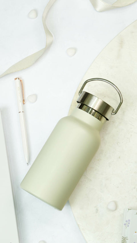 1. SEIK beige stainless steel water bottle with handle, shown on a marble surface with pen and ribbon