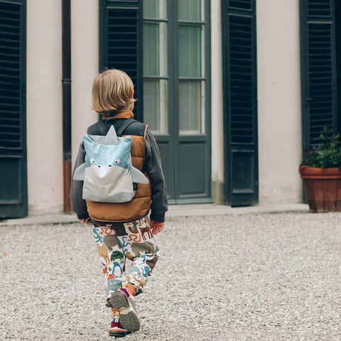 1. Child wearing Muni shark backpack outdoors, showcasing playful design and adjustable straps