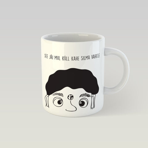 1. SEIK designer mug with 'See jäi mul küll kahe silma vahele' text and whimsical graphic design by Paula Helena Kuklane, shown in studio setting