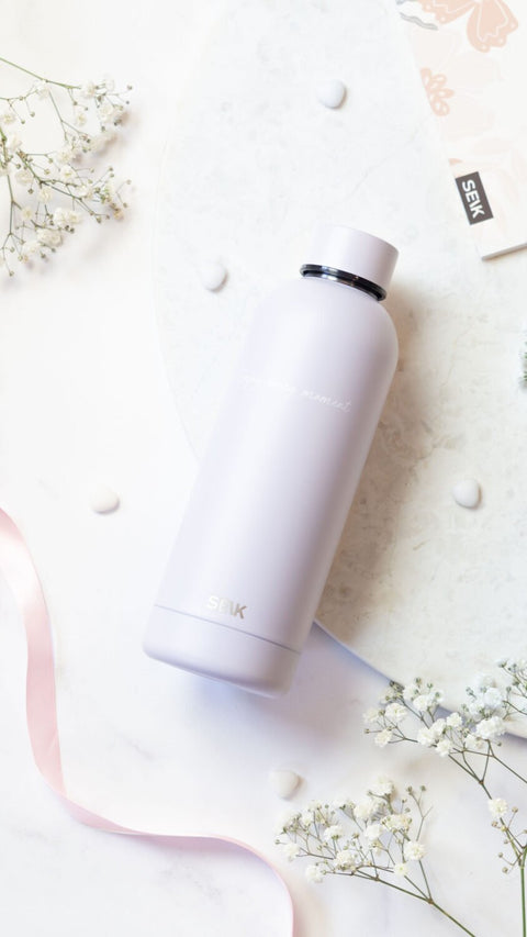 2. SEIK lilac water bottle with 'Enjoy Every Moment' text, displayed on a marble surface with floral decor