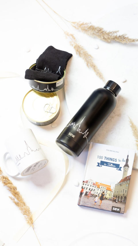 5. SEIK black thermos with Tallinn skyline, shown with a mug and book on a white surface