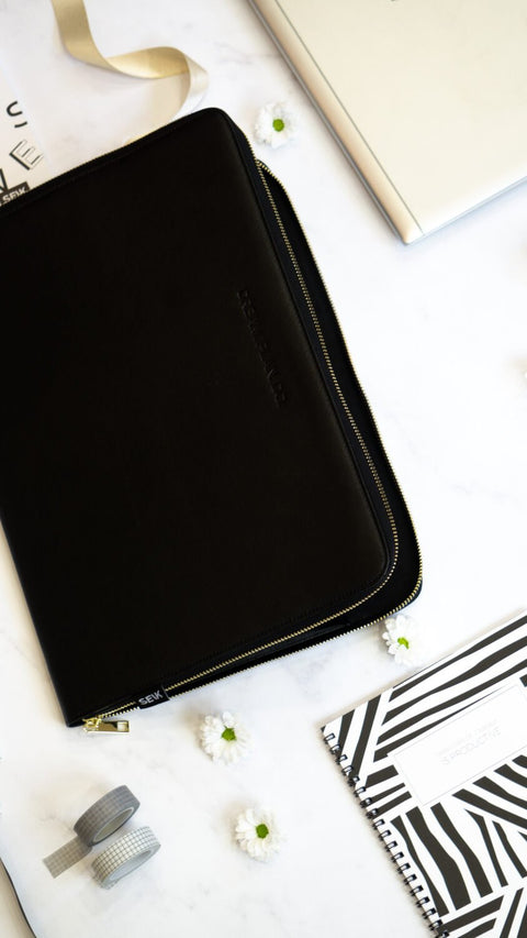 5. SEIK Dream.Plan.Do laptop sleeve on marble surface with accessories, showing sleek design and motivational embossing