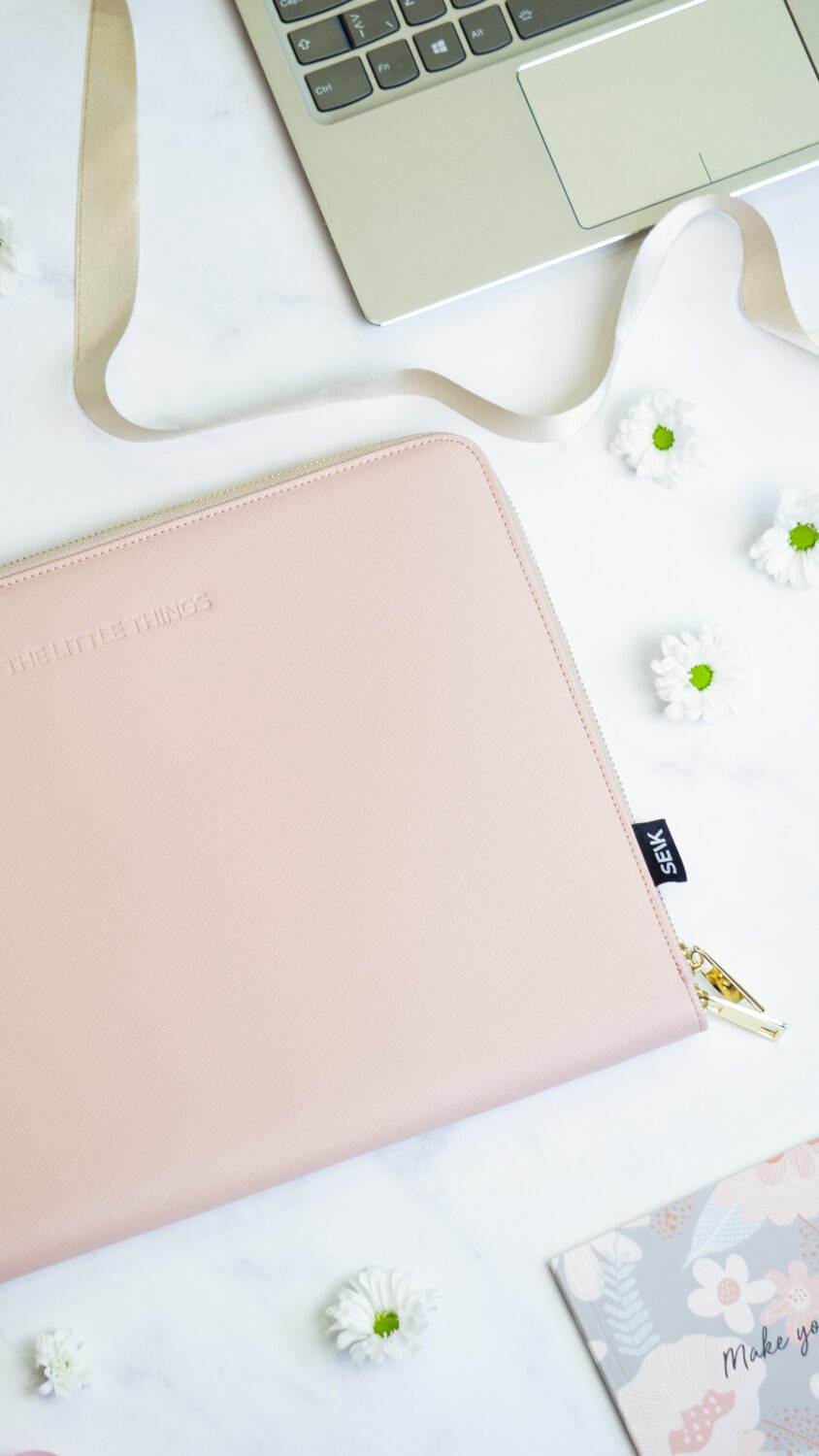 12. SEIK pink laptop sleeve with floral decor, next to a laptop