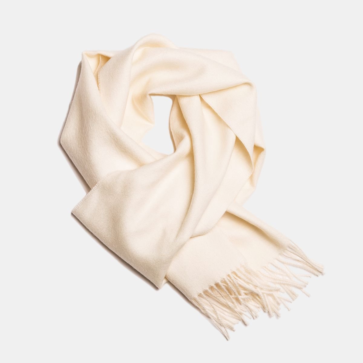 3. Cream Alpaka baby alpaca wool scarf with fringe detail in flat lay