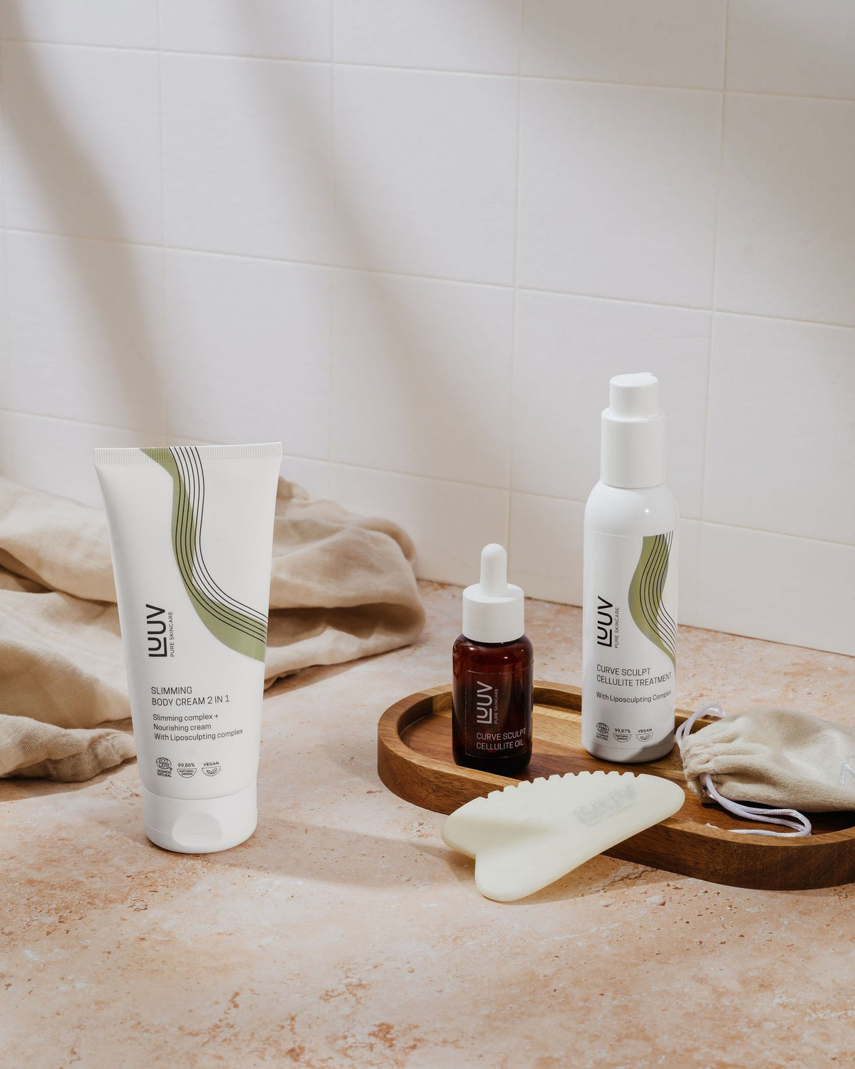 2. LUUV Slimming Body Cream with skincare set on bathroom counter, featuring natural light and soft textures