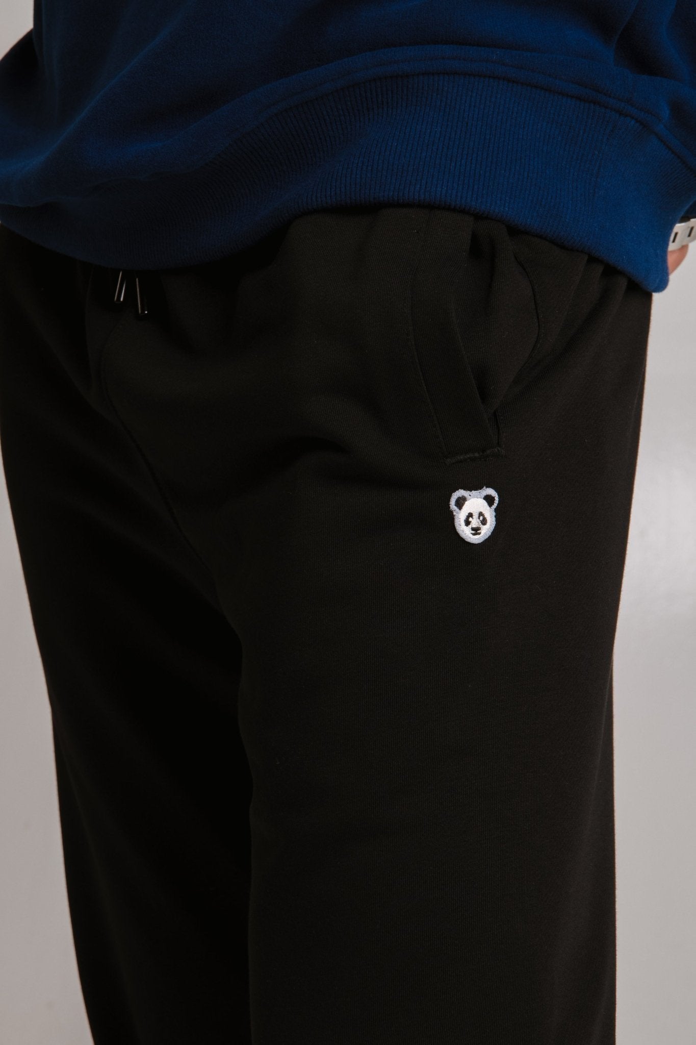 4. Close-up of embroidered panda logo on black Panda Soft Fleece Sweatpants by Sossu