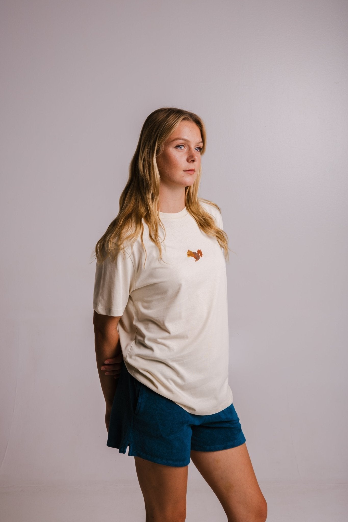 1. Women's Sossu Squirrel T-shirt in Parchment, styled with blue shorts, studio setting