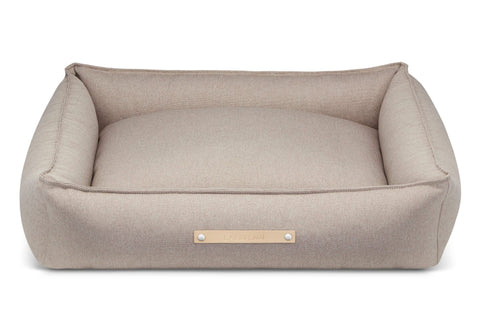 2. Beige Labbvenn Töve dog bed with high sides and leather logo tag shown in studio setting