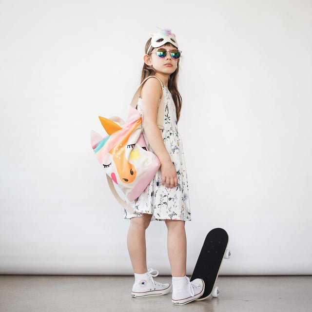 6. Girl with MUNI Unicorn backpack and skateboard, highlighting playful and adventurous style