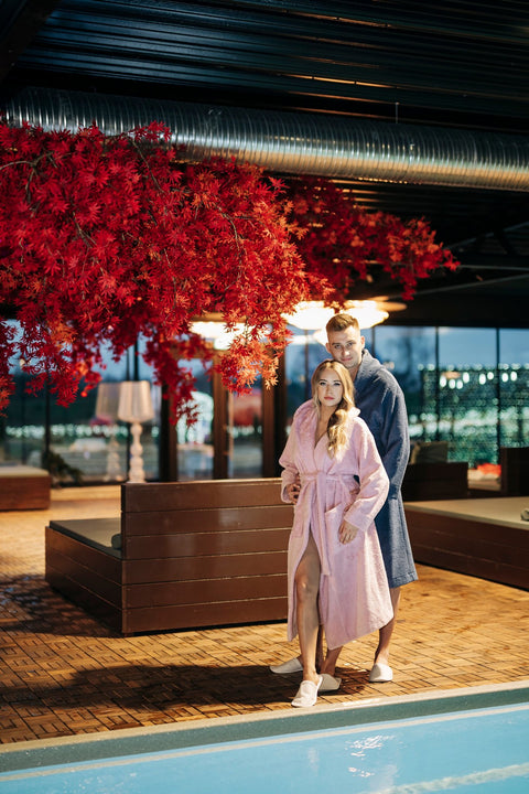 1. Unisex hooded bathrobes by RÄTT worn by male and female models by the poolside