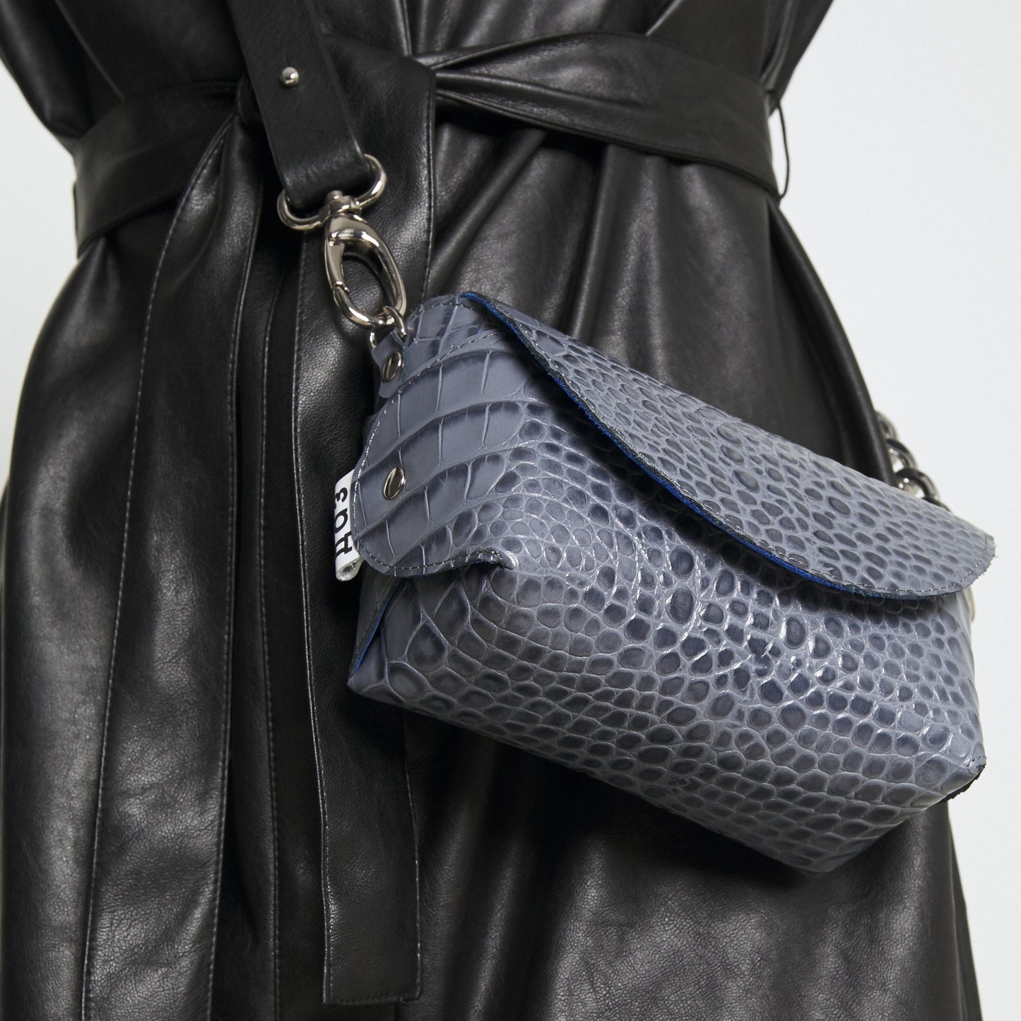 1. Women's handmade grey and blue textured leather shoulder bag by Daz Studio, worn with a black leather dress, showcasing elegant style and functionality
