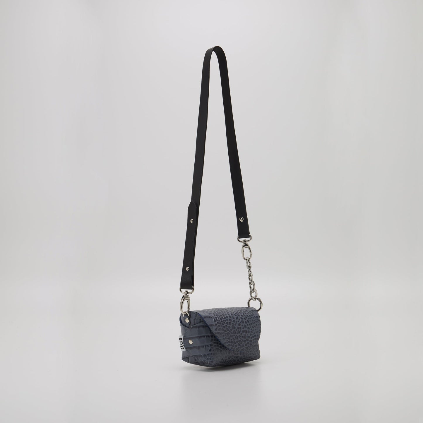 6. Studio shot of Daz Studio's grey and blue textured leather shoulder bag with adjustable strap, showcasing compact size