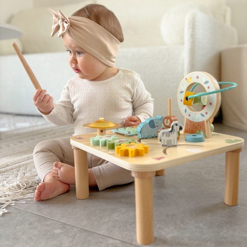 10. Toddler using mallet on Woopie 5-in-1 activity table in living room setting