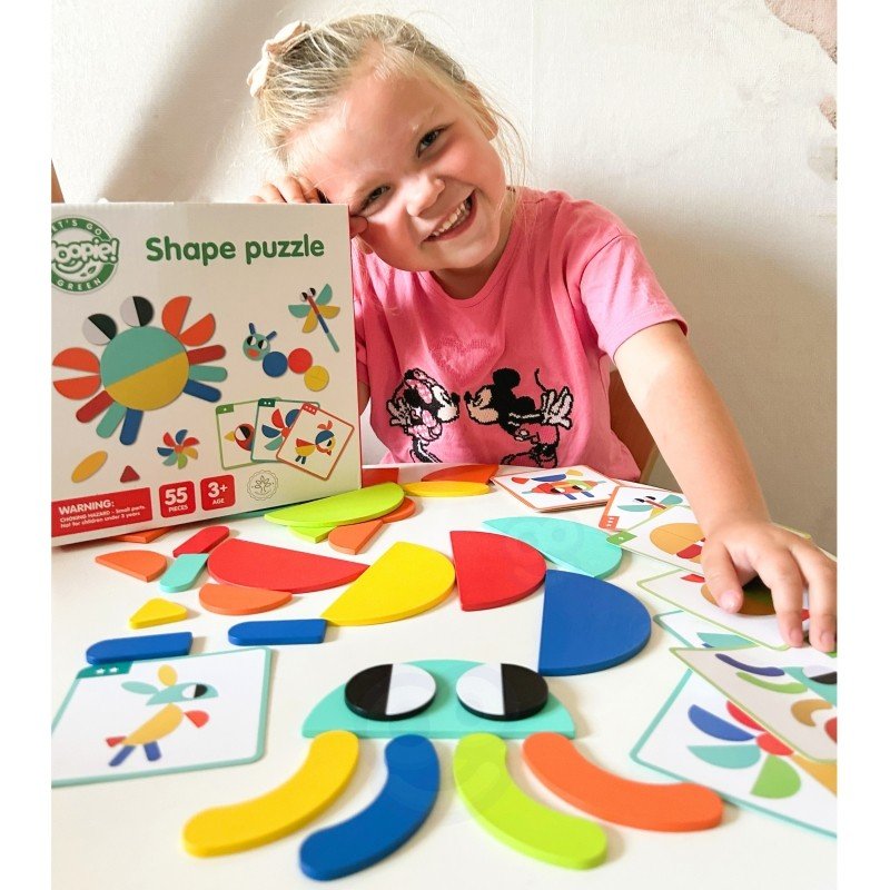 11. Smiling child with colorful wooden shapes and Woopie Let's Go Green puzzle box