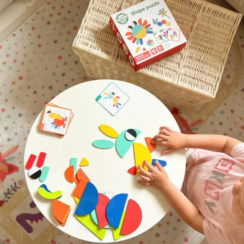 1. Child playing with colorful wooden Montessori shape puzzle on round table with cards and blocks