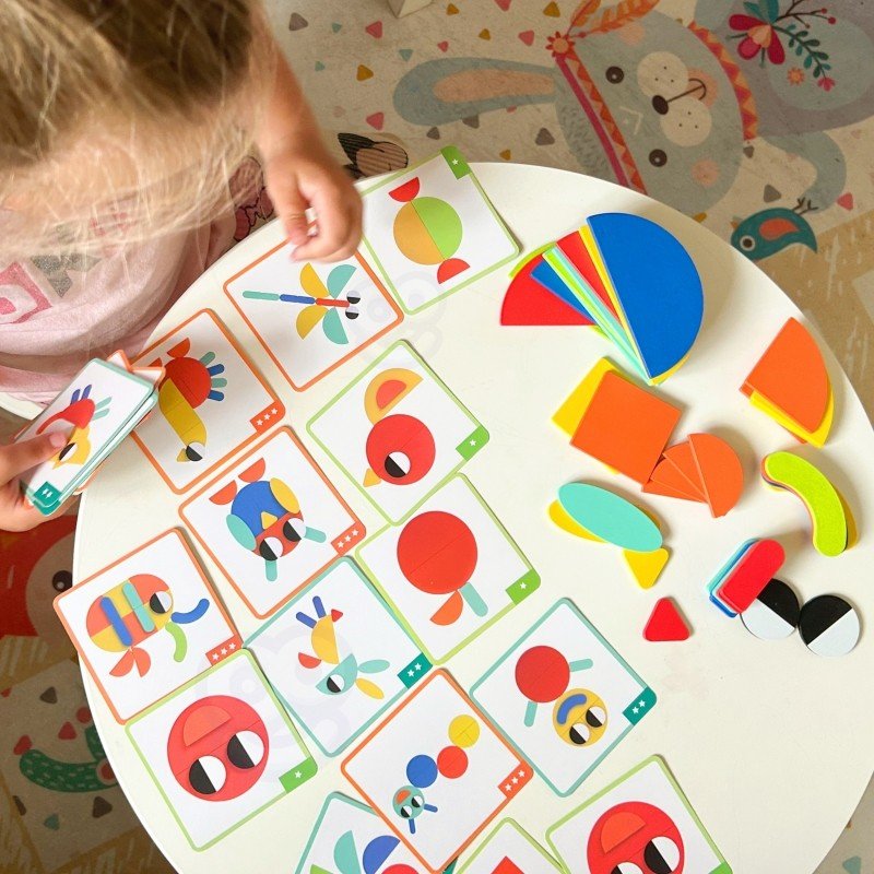 7. Child arranging colorful wooden blocks with multiple pattern cards on table
