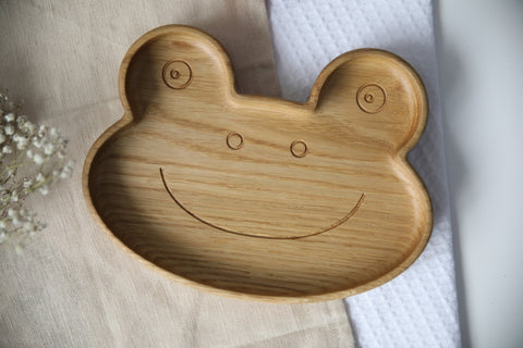 2. Close-up of wooden frog-shaped plate highlighting smooth, polished surface and carved smile