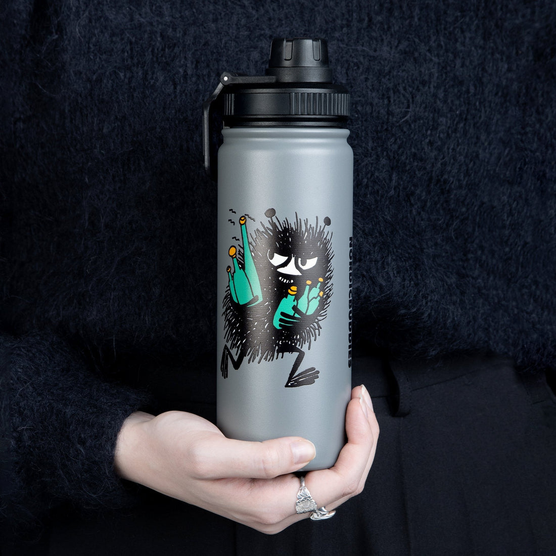 1. Stinky Thermal Everyday Bottle by Moomin held by a person, showcasing the playful design and practical handle