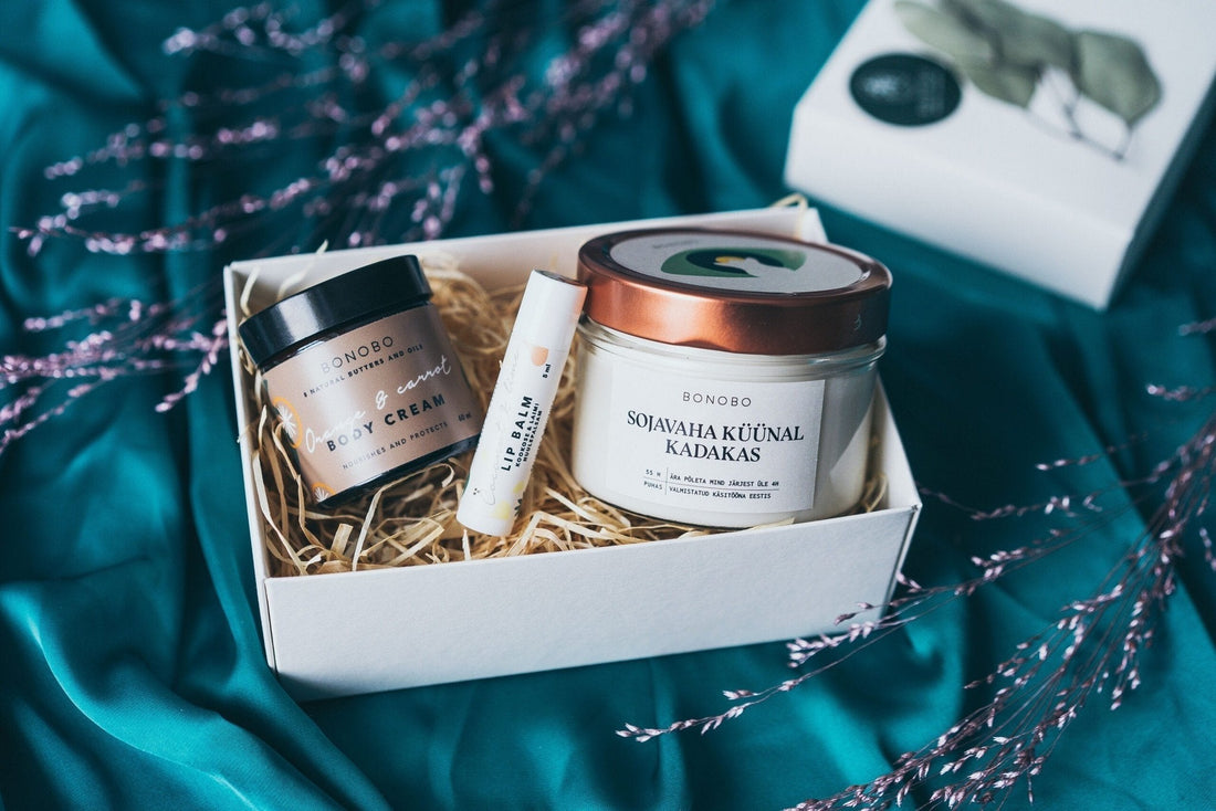 1. BONOBO gift box with juniper candle, orange body cream, and avocado lip balm on teal fabric