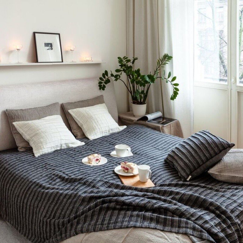 1. Black and gray linen-cotton bedcover on a bed in a cozy bedroom with pillows, plants, and breakfast setup