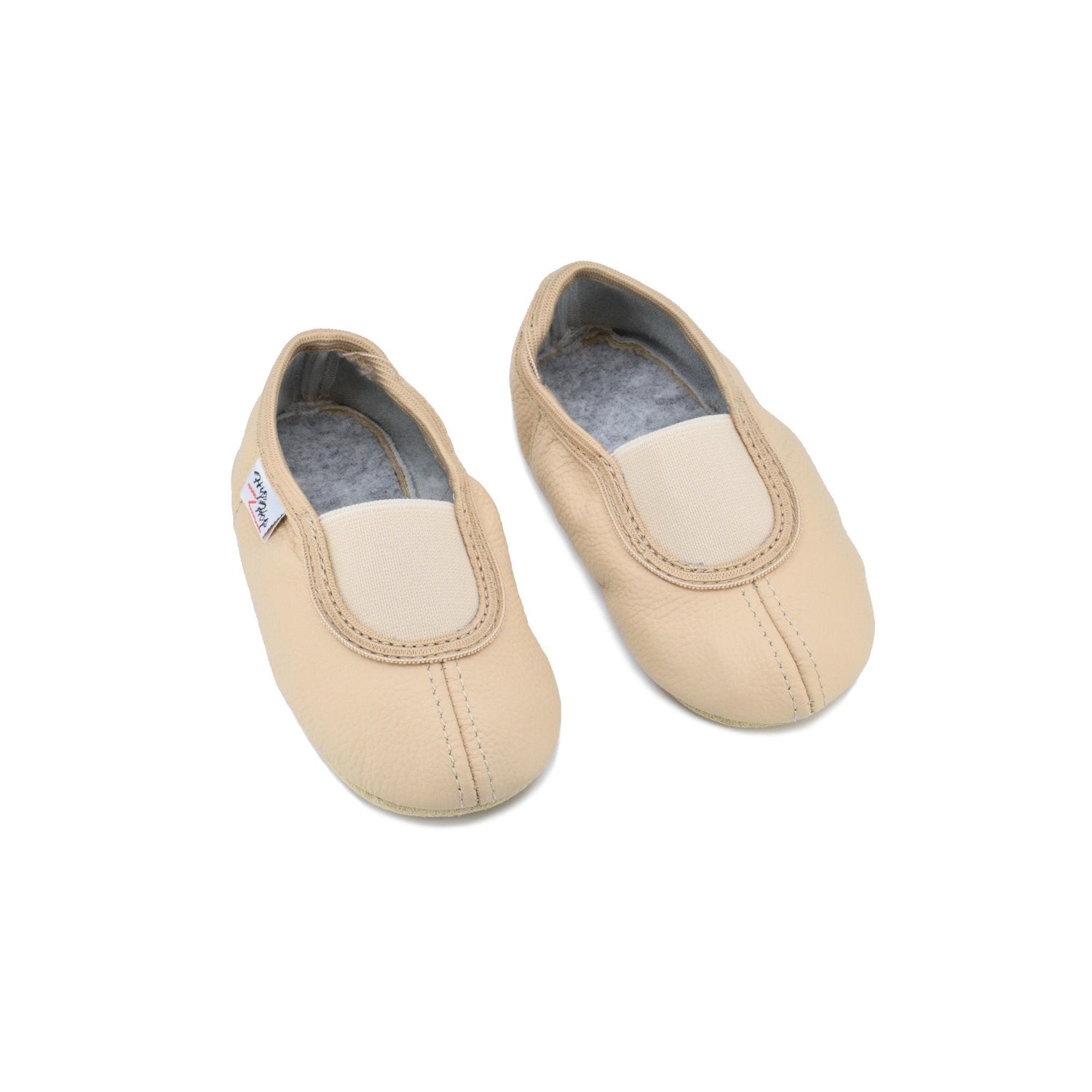1. Child wearing Omaking dark grey felt slippers in a cozy home library setting