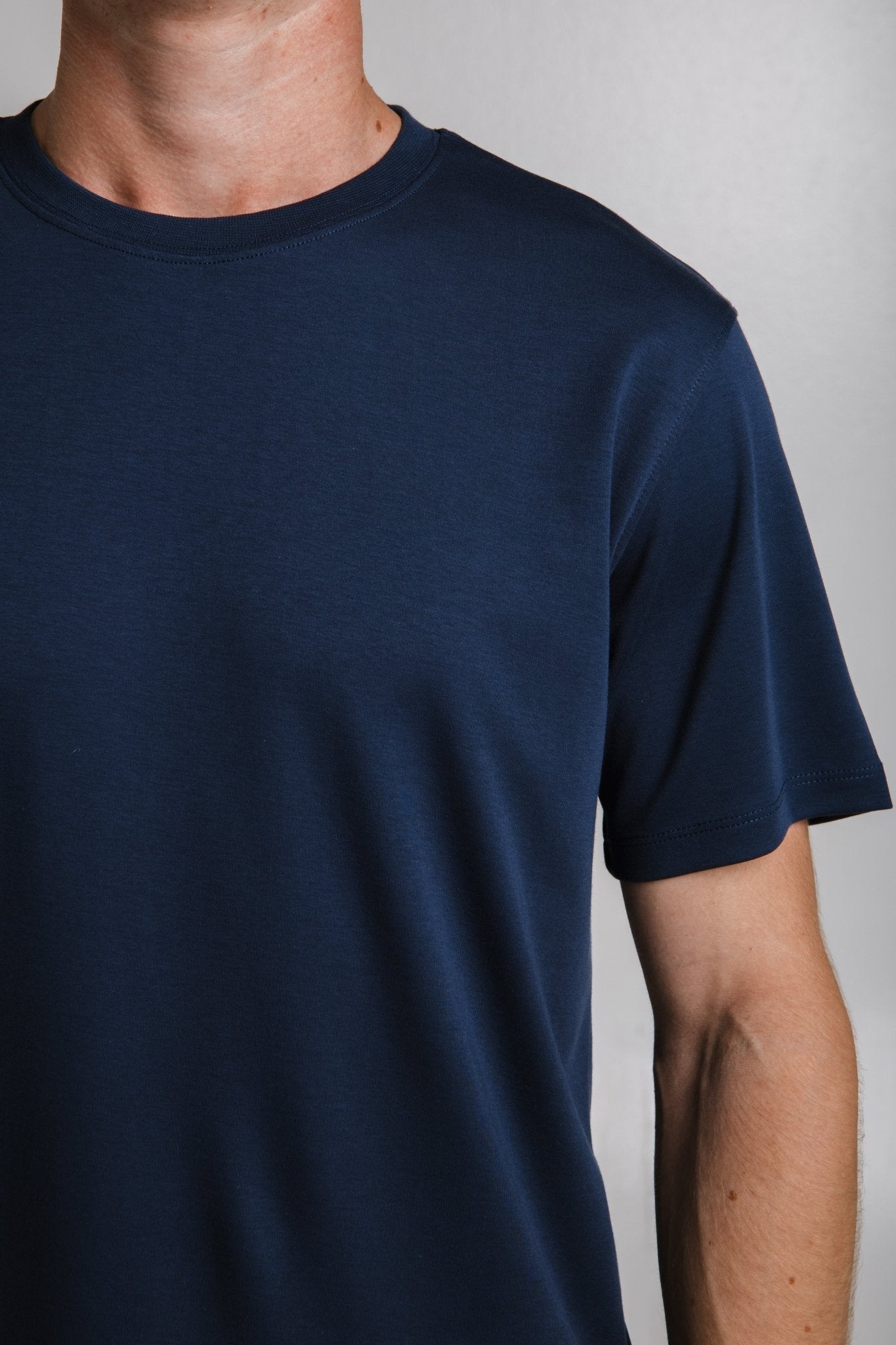 1. Unisex green organic cotton t-shirt with 'dad' embroidery on collar, hanging on a rack in a lifestyle setting