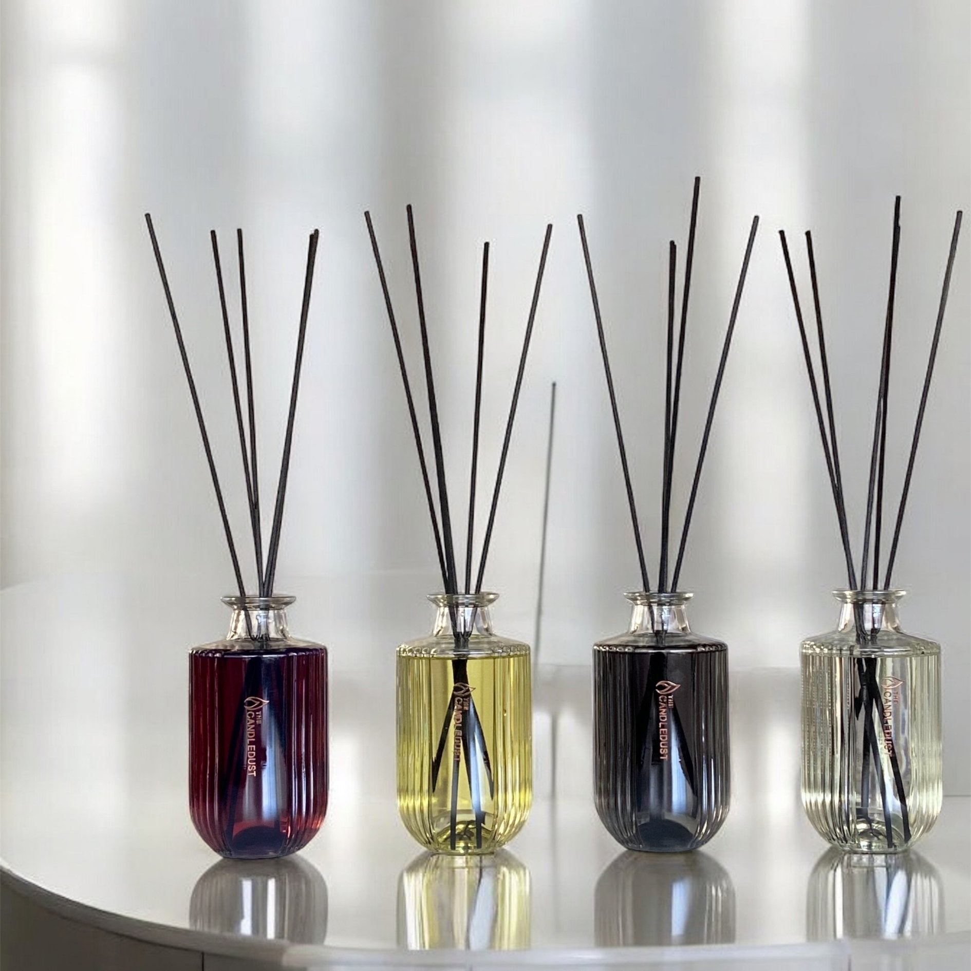 11. Collection of Candledust diffusers in various colors on white surface