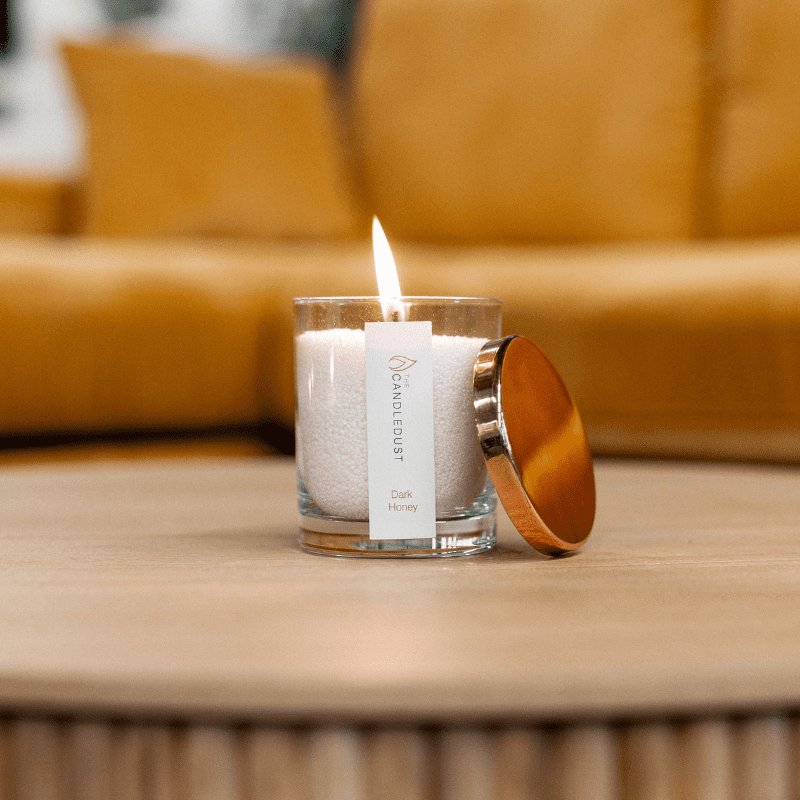 3. Candledust Dark Honey powdered candle lit on wooden table, lifestyle setting