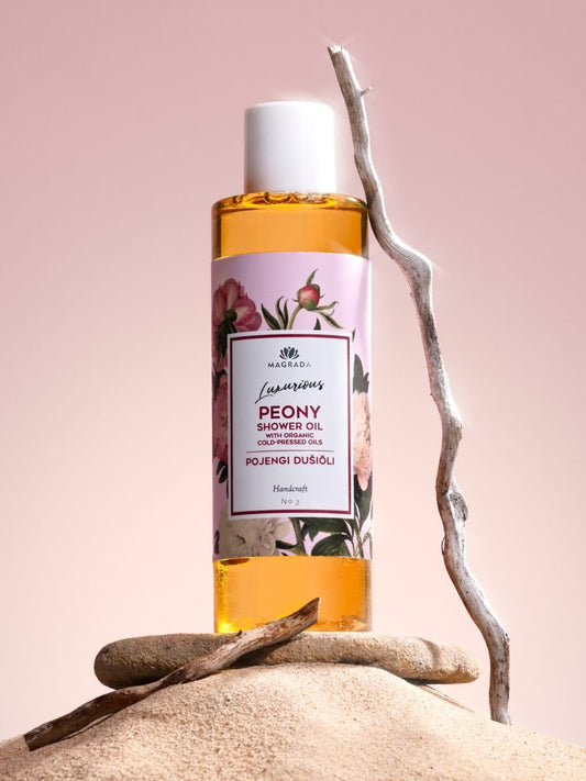 1. Magrada Peony Shower Oil with organic fruit oils in a 200 ml bottle, displayed on sand with a pink background