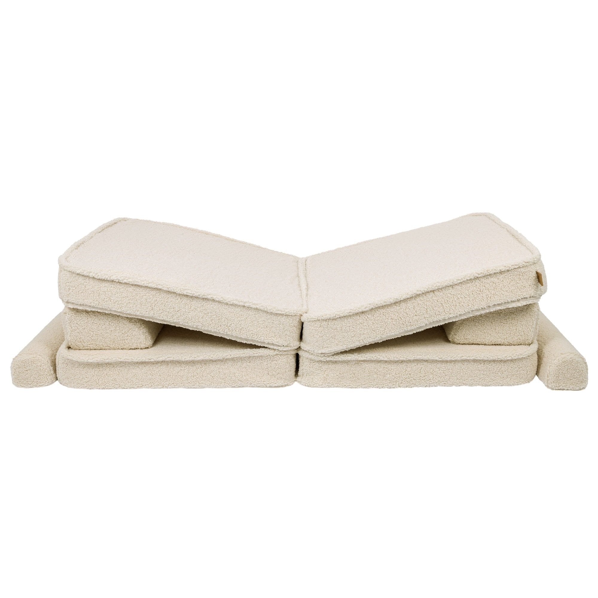 5. Cream sofa cushions folded in a zigzag pattern, showcasing modular flexibility in a studio setting