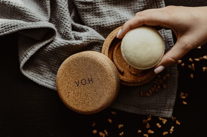 5. V.O.H solid shampoo in cork case with cotton bag, held by a person
