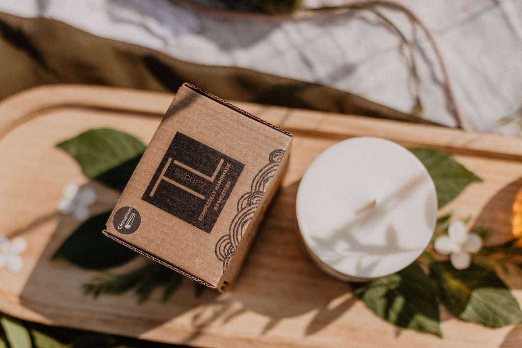 7. Overhead shot of TL Candles packaging and white soy wax candle on wooden tray with floral accents